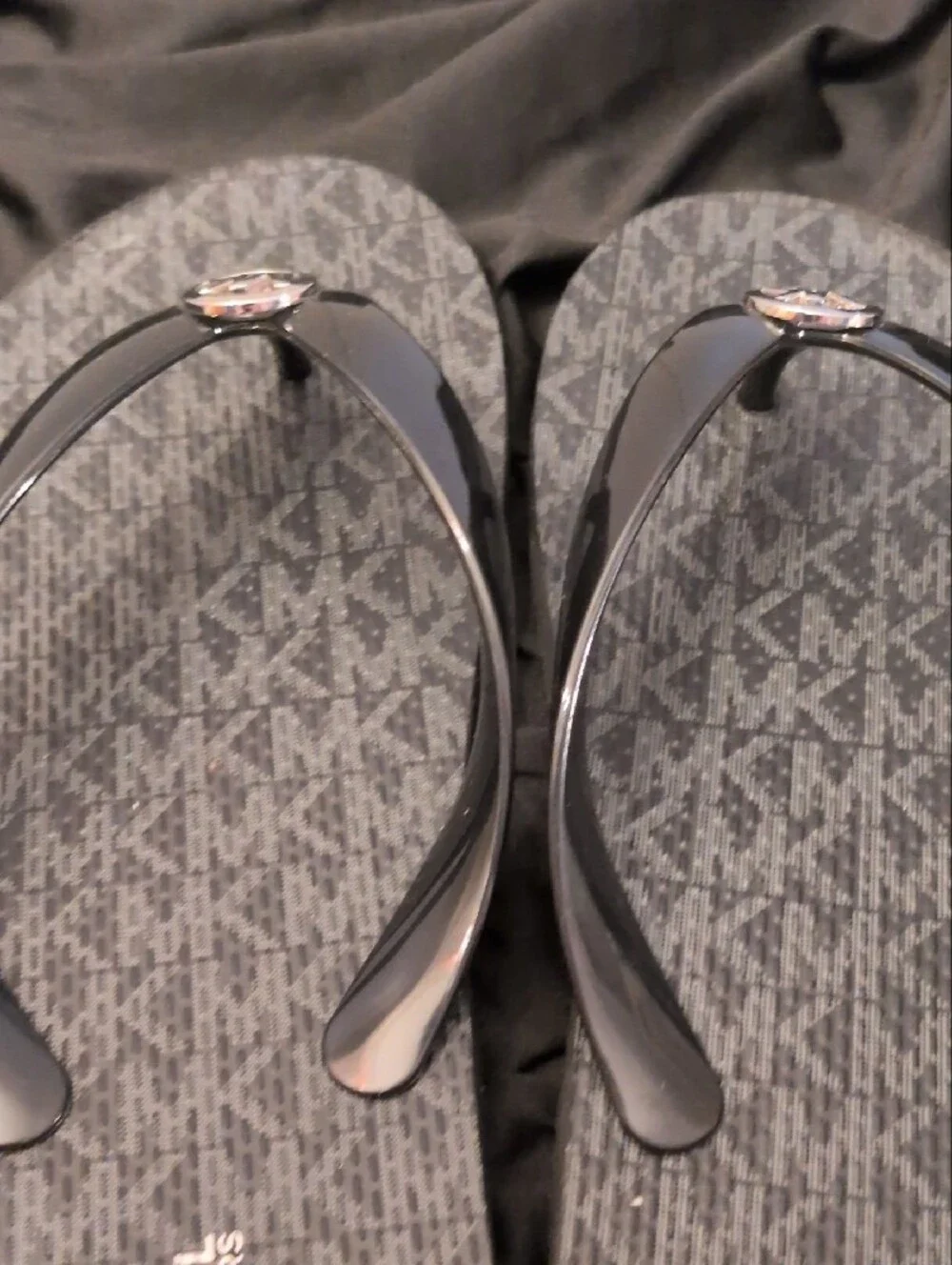 Michael Kors Black Logo Monogram Flip Flops with Silver MK Medallions.